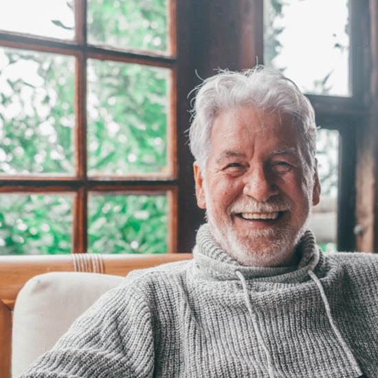 an older man smiling and laughing at home