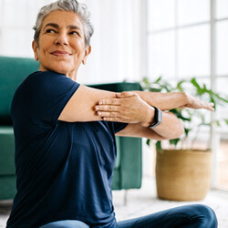 woman smiling while stretching at home