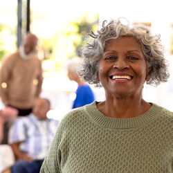 woman in green sweater smiling outside