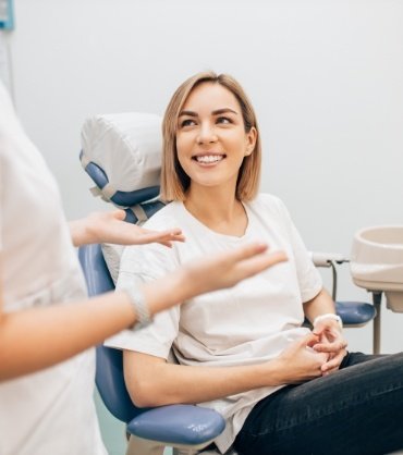 Woman in dental chair talking to her dentist