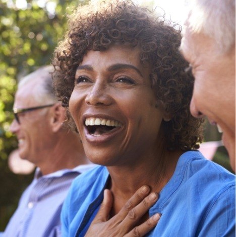 Older woman in blue blouse smiling outside