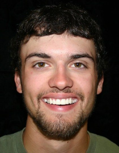 Young man smiling brightly after seeing dentist in Grand Island