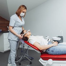 Dental assistant removing nasal mask after procedure is complete