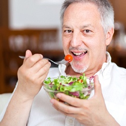 Man eating a salad and smiling