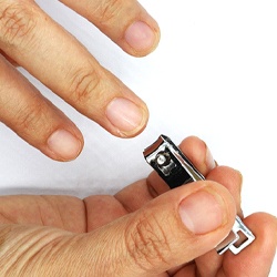 Man using nail clippers to trim fingernails