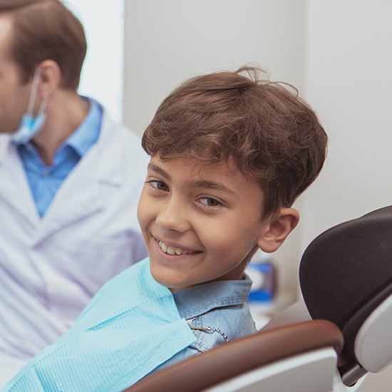 young boy smiling in dental chair