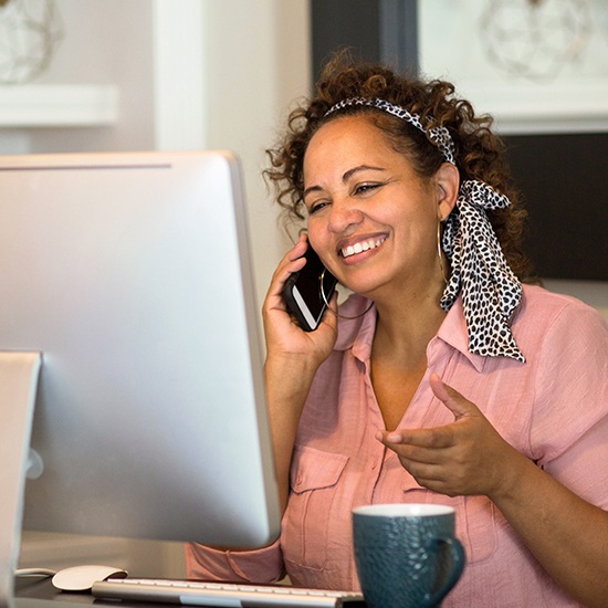 woman talking on phone at computer