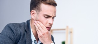 man holding jaw in pain