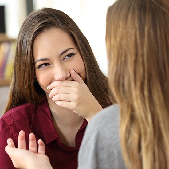 woman covering smile